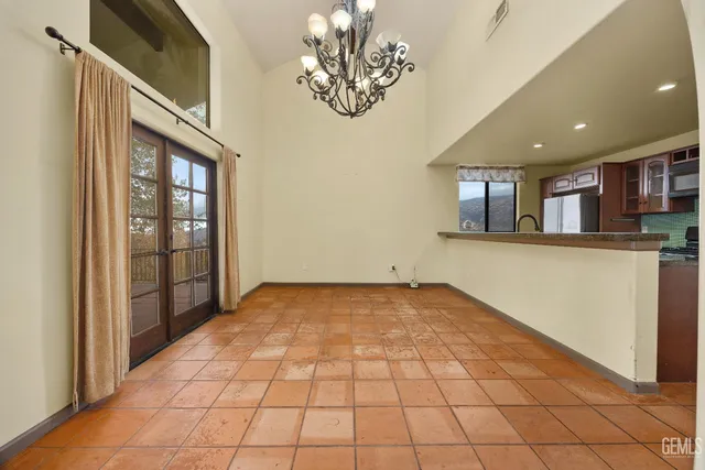 a kitchen with granite countertop a refrigerator and cabinets