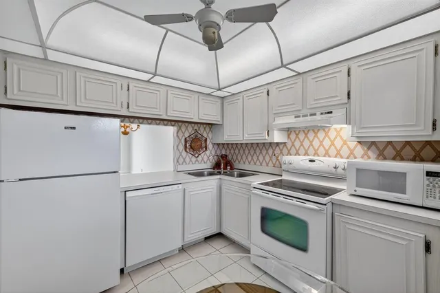 a kitchen with cabinets and white stainless steel appliances