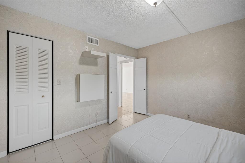 1541 South Ocean Boulevard, Unit 405 Lauderdale-by-the-Sea, FL 33062 - Photo 21 of 57 a bedroom with a bed and a shower