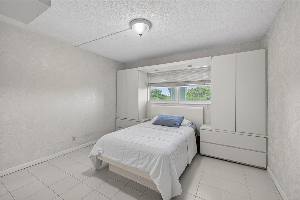 1541 South Ocean Boulevard, Unit 405 Lauderdale-by-the-Sea, FL 33062 - Photo 22 of 57 a bedroom with a bed and a window