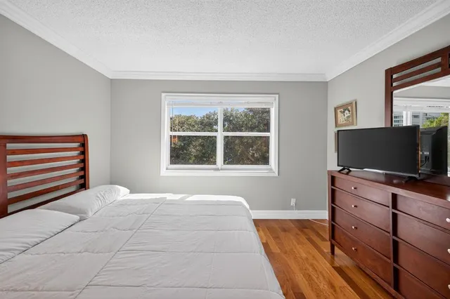 a bedroom with a bed and a mirror on dresser