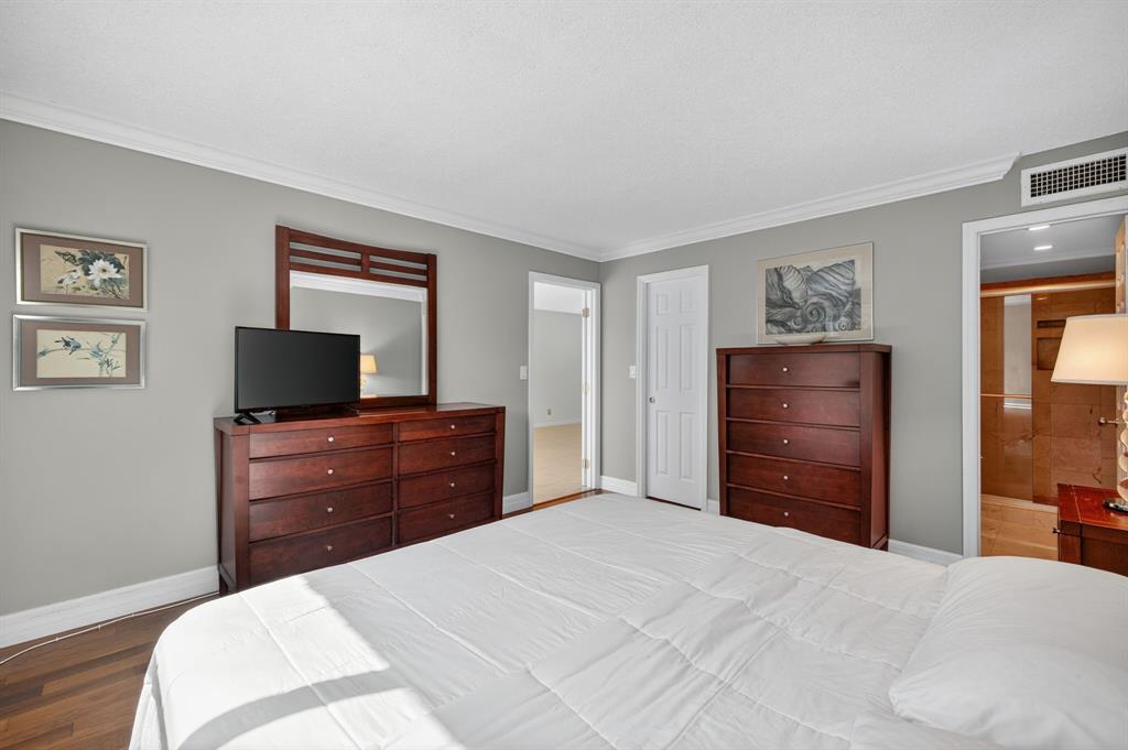 1541 South Ocean Boulevard, Unit 405 Lauderdale-by-the-Sea, FL 33062 - Photo 27 of 57 a bedroom with a bed and a mirror on dresser