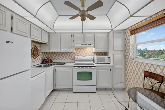 a kitchen with a stove cabinets and white appliances