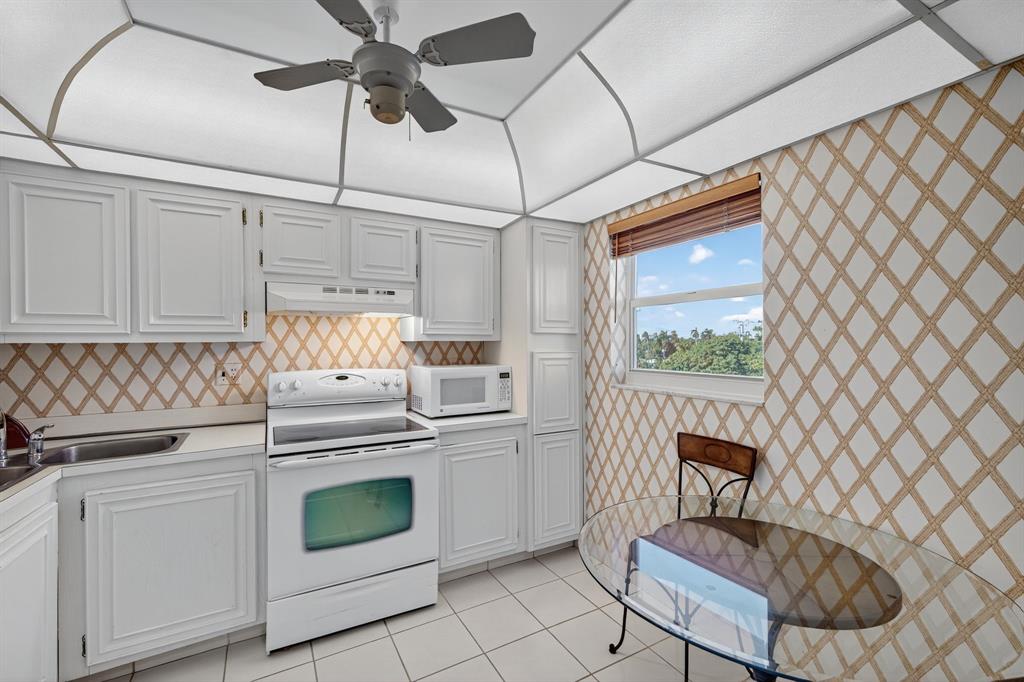 1541 South Ocean Boulevard, Unit 405 Lauderdale-by-the-Sea, FL 33062 - Photo 10 of 57 a kitchen with a stove cabinets and window