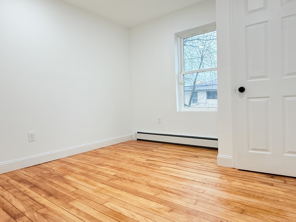 23 Bellevue Street, Unit 2 Worcester, MA 01609 - Photo 14 of 19 an empty room with wooden floor and windows