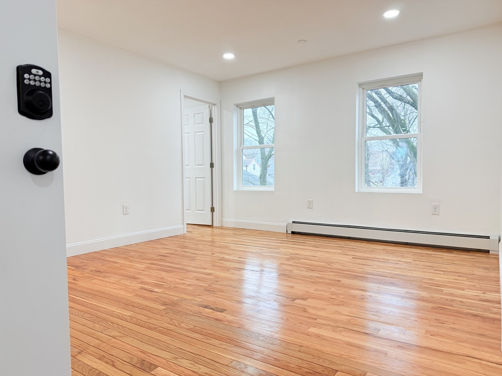 23 Bellevue Street, Unit 2 Worcester, MA 01609 - Photo 4 of 19 a view of an empty room with wooden floor and a window