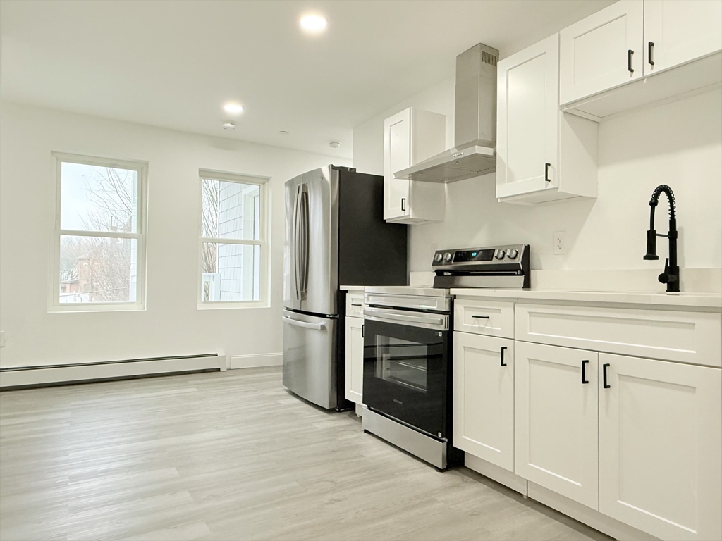 23 Bellevue Street, Unit 2 Worcester, MA 01609 - Photo 5 of 19 a kitchen with stainless steel appliances white cabinets and a refrigerator