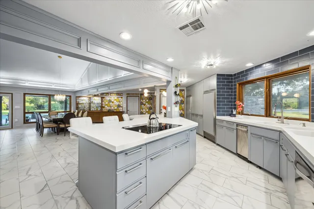 a kitchen with a sink and chairs