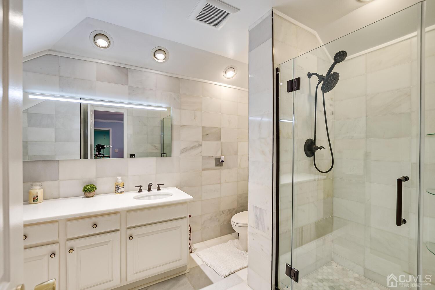 39 Martinsville Road Bernards, NJ 07920 - Photo 44 of 65 a bathroom with a shower sink vanity mirror and toilet