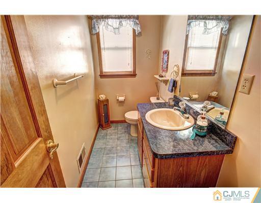 126 North Hill Road Colonia, NJ 07067 - Photo 12 of 25 a bathroom with a sink a mirror and a toilet
