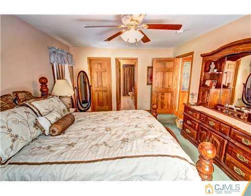 126 North Hill Road Colonia, NJ 07067 - Photo 13 of 25 a bedroom with a large bed and a chandelier