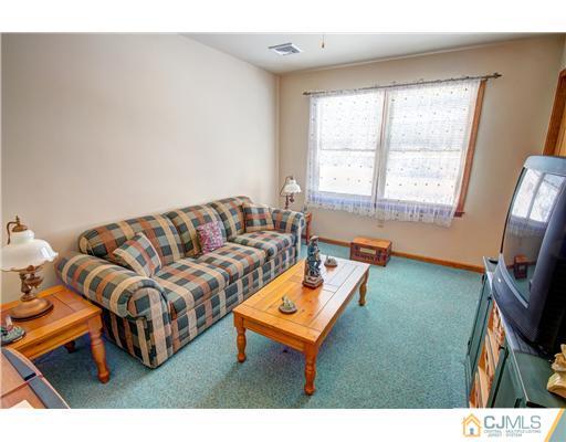 126 North Hill Road Colonia, NJ 07067 - Photo 17 of 25 a living room with furniture a flat screen tv and a window
