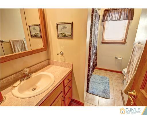 126 North Hill Road Colonia, NJ 07067 - Photo 20 of 25 a bathroom with a sink and mirror with bathtub