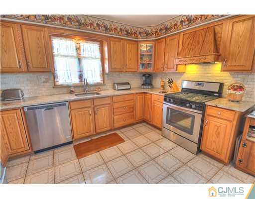 126 North Hill Road Colonia, NJ 07067 - Photo 8 of 25 a kitchen with stainless steel appliances granite countertop a stove a sink and a microwave