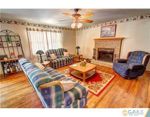 126 North Hill Road Colonia, NJ 07067 - Photo 10 of 25 a living room with furniture a fireplace and a large mirror