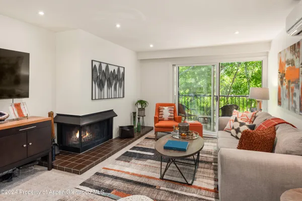 a living room with furniture a flat screen tv and a fireplace