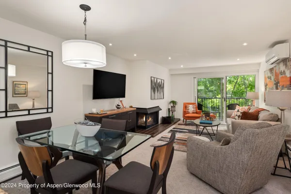a living room with furniture a flat screen tv and a large window