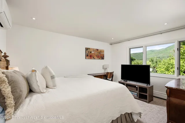 a bedroom with a bed and a flat screen tv