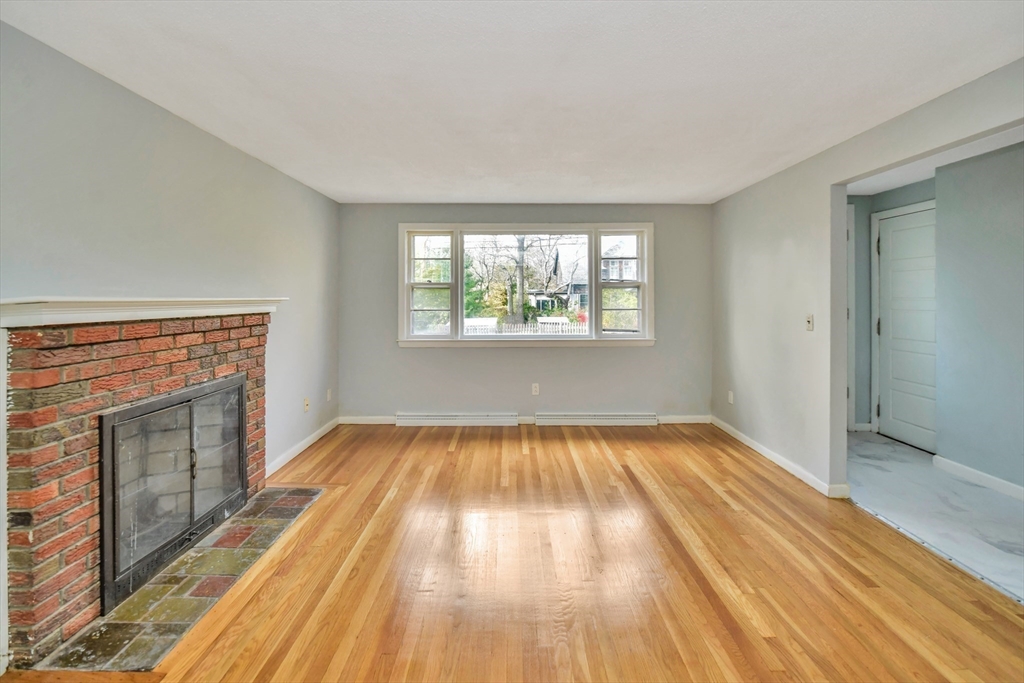 16 Prospect Street Boston, MA 02136 - Photo 17 of 37 an empty room with wooden floor fireplace and windows