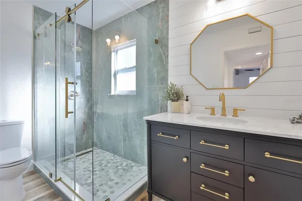 a bathroom with a sink a toilet and shower