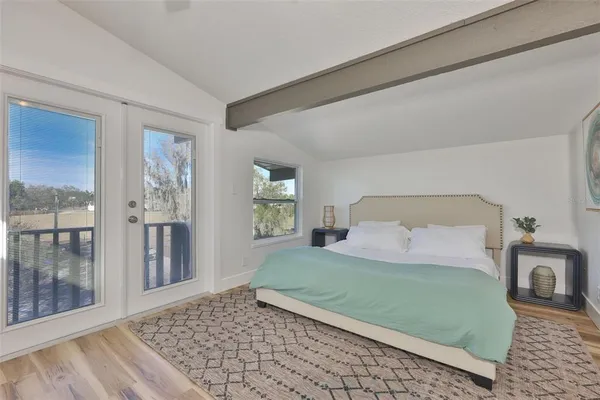 a bedroom with a large bed and a wooden floor