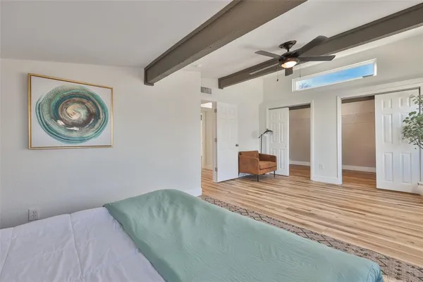 a view of a bedroom with a bed and wooden floor