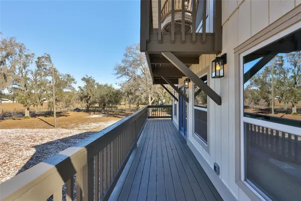 a view of a balcony with wooden floor and fence