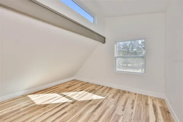 a view of a room with wooden floor and window