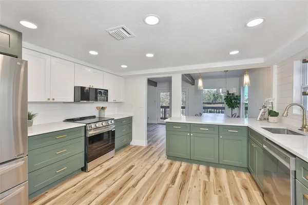 a large kitchen with stainless steel appliances granite countertop a stove and a sink
