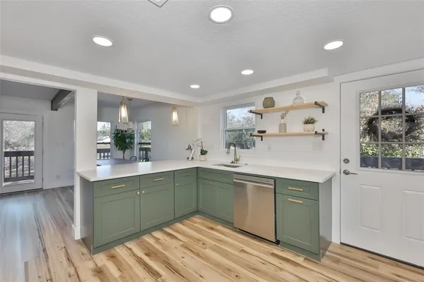 a kitchen with a sink cabinets and wooden floor