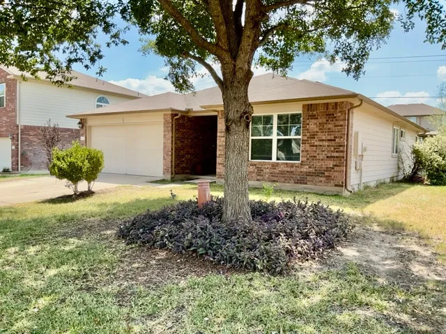 a front view of a house with a yard and a garage