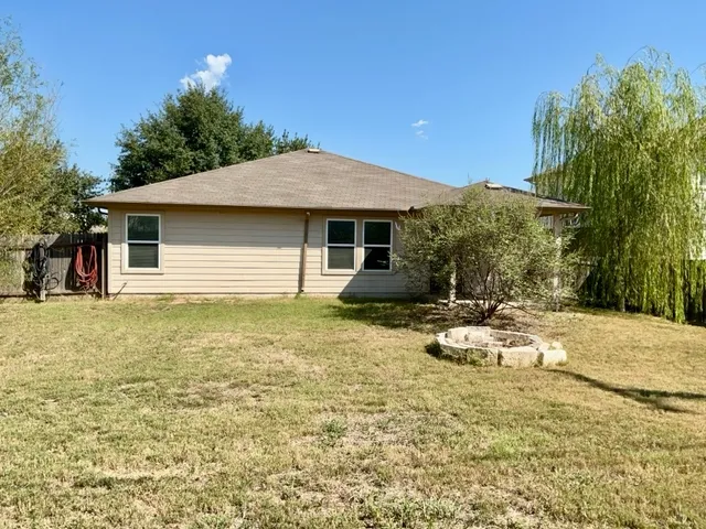 a view of a house with backyard and sitting area