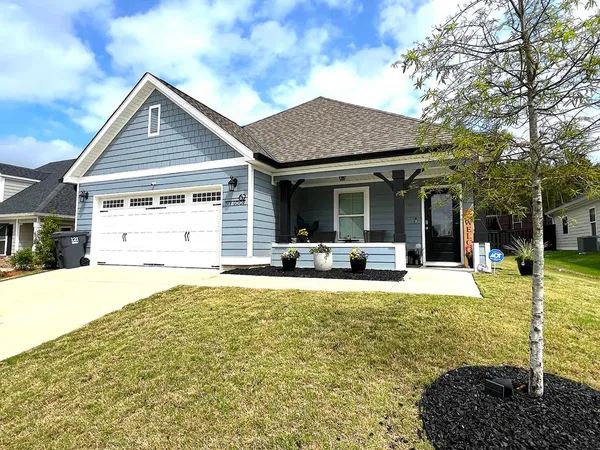 a front view of a house with a yard outdoor seating and garage