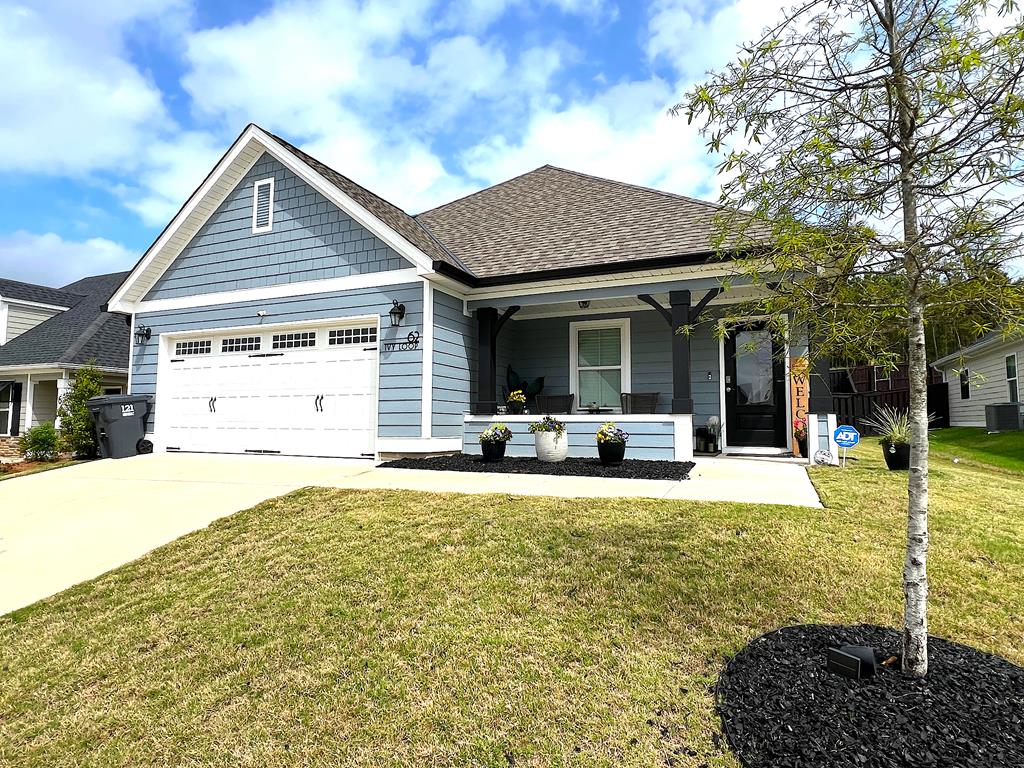 a front view of a house with a yard outdoor seating and garage