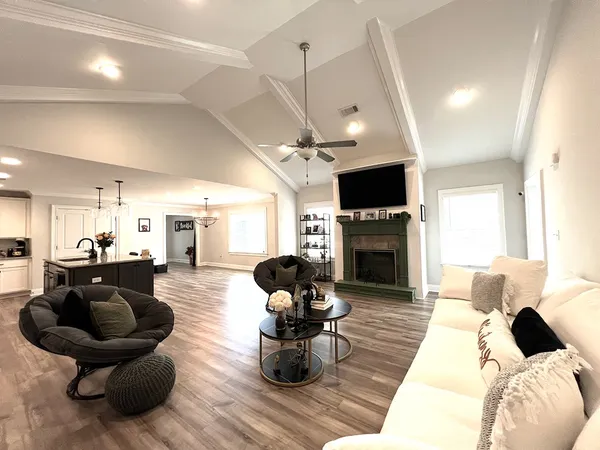 a living room with furniture a fireplace and a flat screen tv