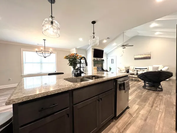 a kitchen with kitchen island granite countertop a sink stainless steel appliances and cabinets