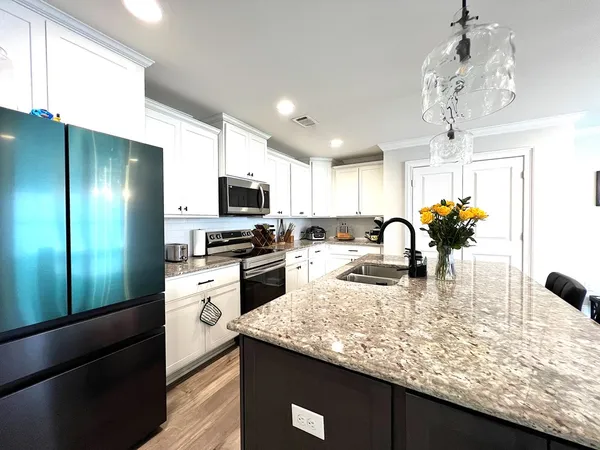 a kitchen with granite countertop stainless steel appliances a sink stove and cabinets