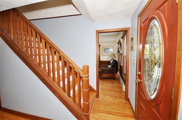 130 Stow Road Boxborough, MA 01719 - Photo 3 of 19 a view of a hallway with wooden floor and staircase
