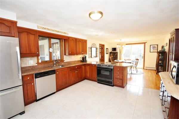 130 Stow Road Boxborough, MA 01719 - Photo 7 of 19 a large kitchen with kitchen island granite countertop a large counter top stainless steel appliances a sink and a large window