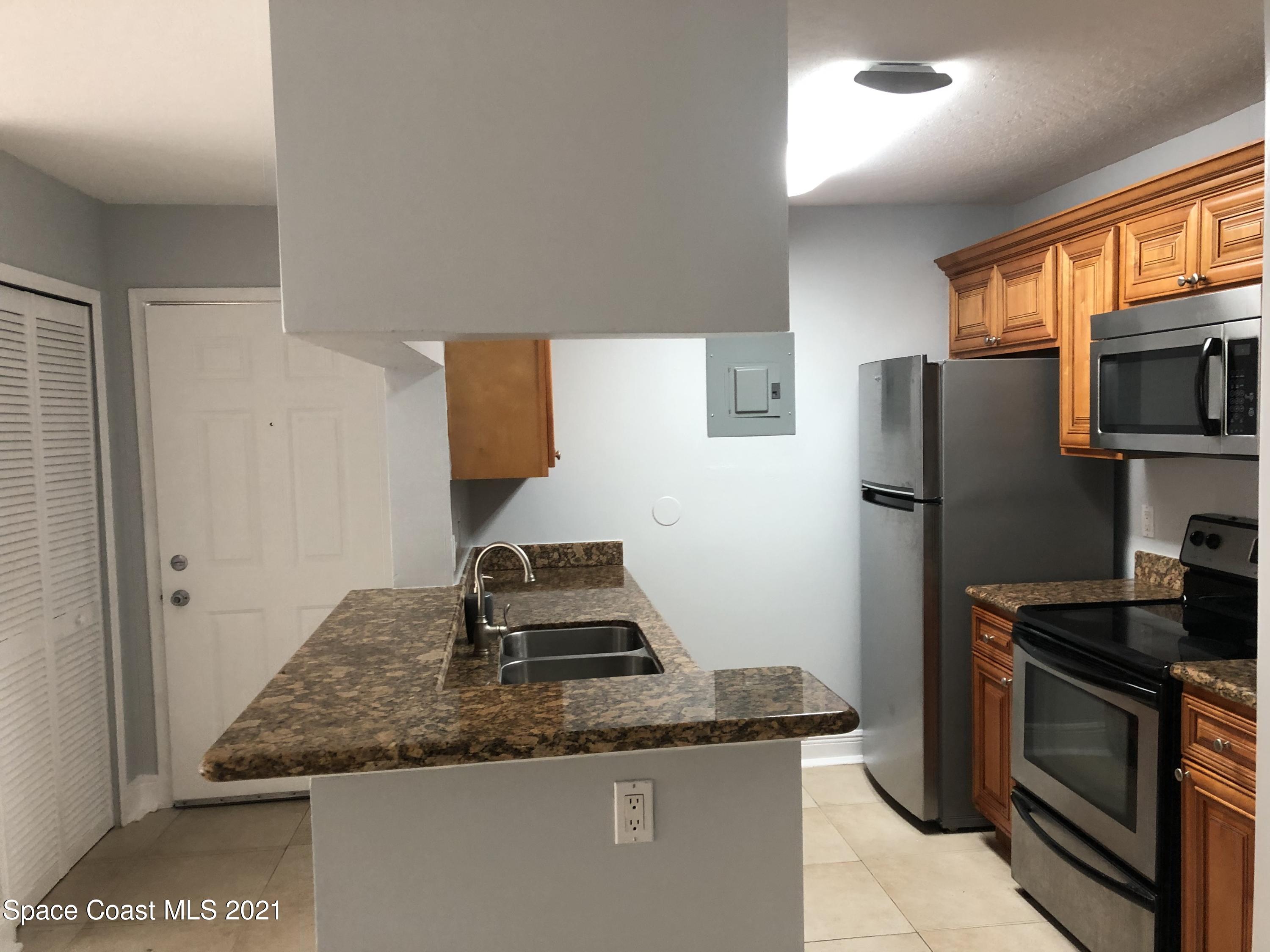7667 North Wickham Road, Unit 406 Melbourne, FL 32940 - Photo 15 of 28 KITCHEN FRONT DOOR