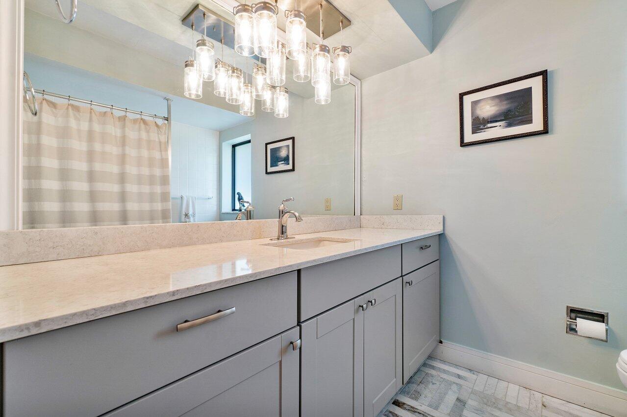 1280 Singer Drive Singer Island, FL 33404 - Photo 13 of 39 a bathroom with a sink a large mirror and a shower