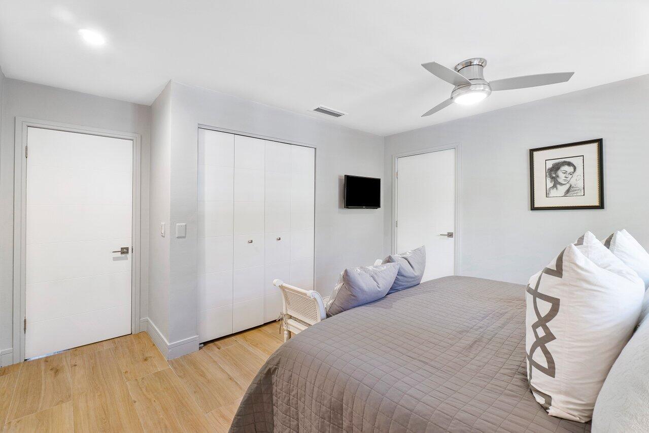 1280 Singer Drive Singer Island, FL 33404 - Photo 17 of 39 a bedroom with a large bed and a tv