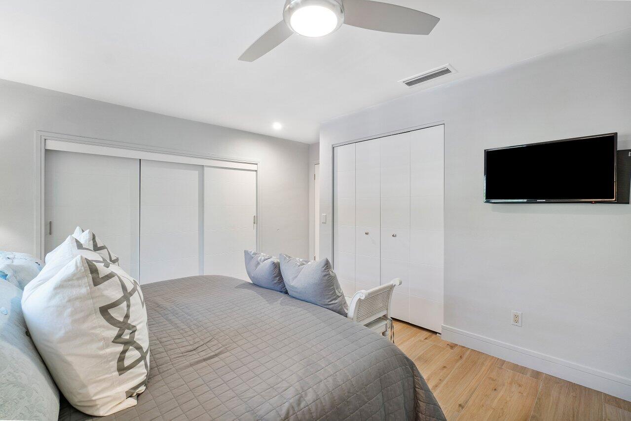 1280 Singer Drive Singer Island, FL 33404 - Photo 18 of 39 a bedroom with a bed and a flat screen tv