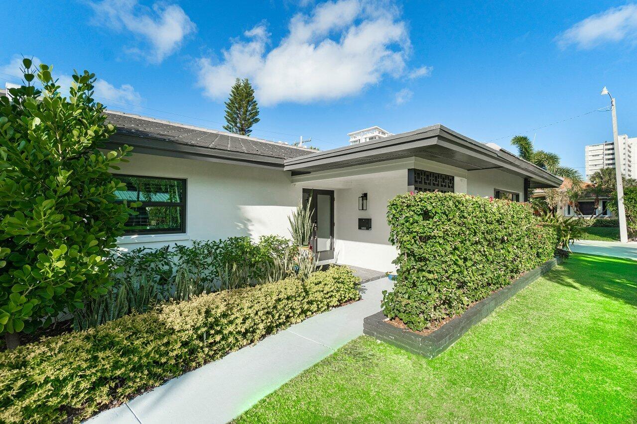 1280 Singer Drive Singer Island, FL 33404 - Photo 4 of 39 a front view of a house with garden