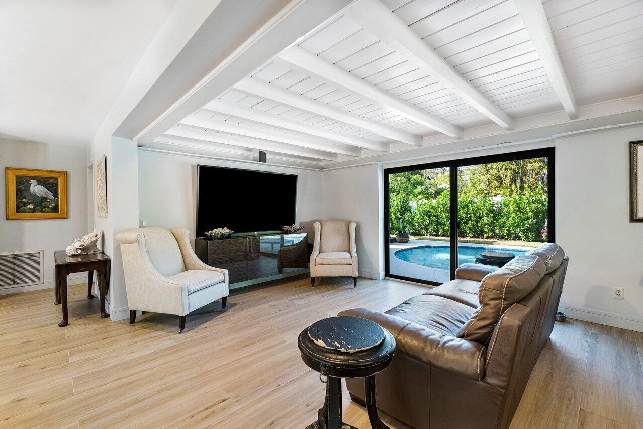 1280 Singer Drive Singer Island, FL 33404 - Photo 6 of 39 a living room with furniture a flat screen tv and a large window