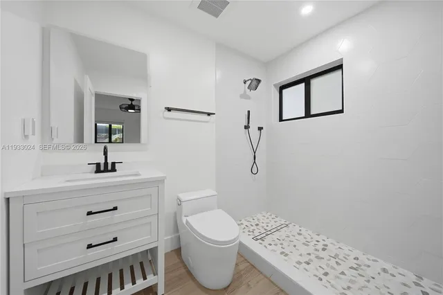 a view of a kitchen with refrigerator and white cabinets