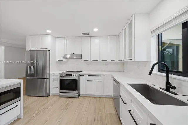 a kitchen with a sink stainless steel appliances and cabinets