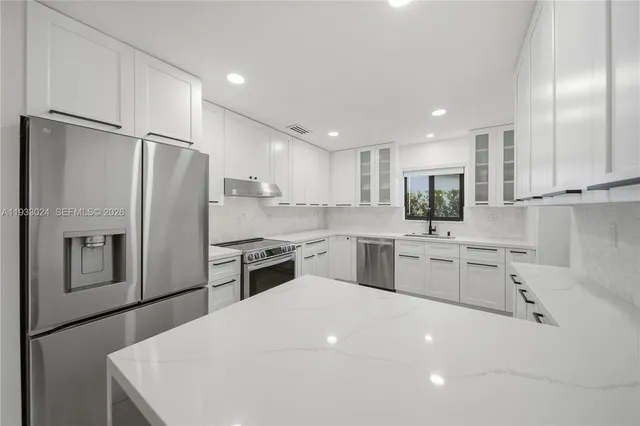 a kitchen with white cabinets and stainless steel appliances
