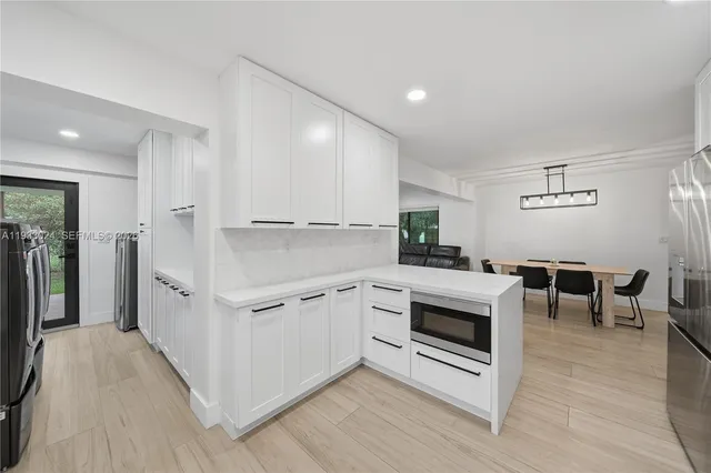 a kitchen with white cabinets and stainless steel appliances