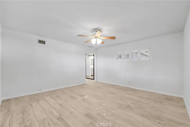 a view of a room with a chandelier fan and windows